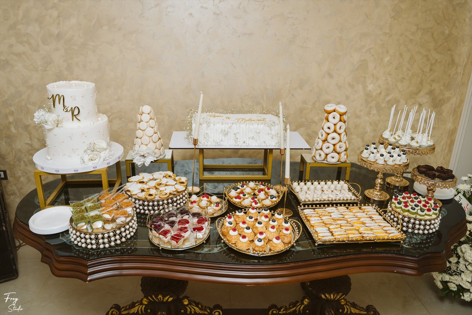 The full engagement sweet table with the monogram cake, macaron tower and gold platters