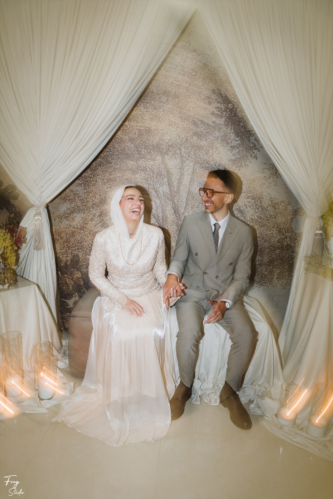 Reem and Mohamed seated holding hands, laughing together