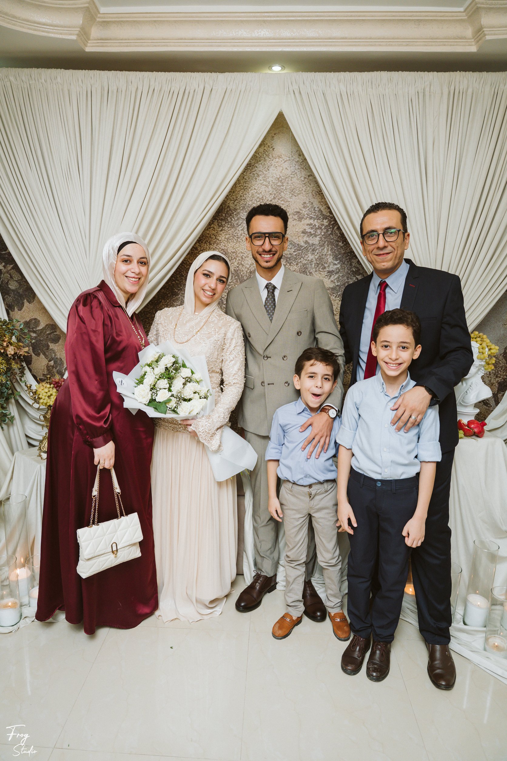 Mohamed and Reem with Mohamed&rsquo;s family, including two young boys in shirts and ties