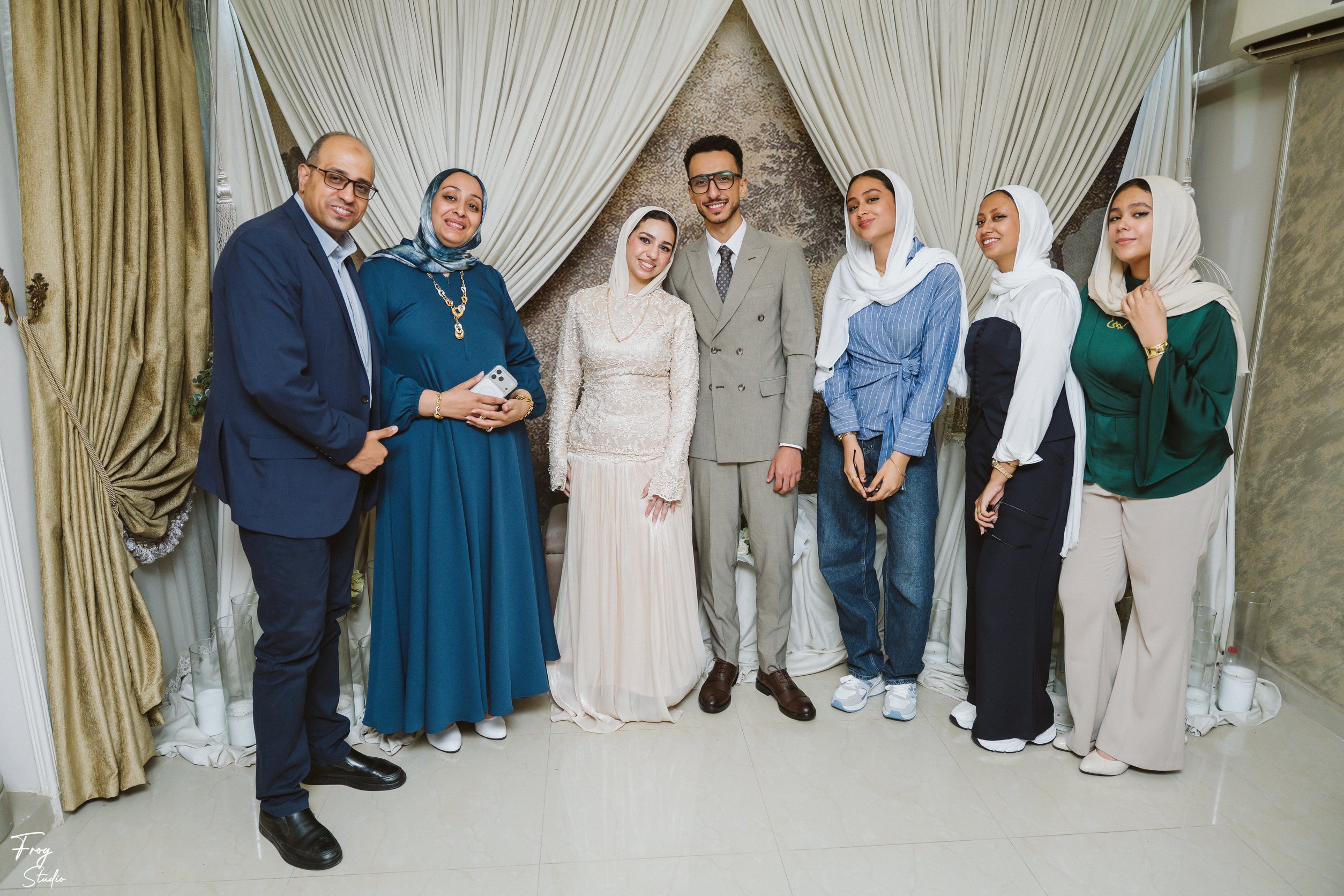 A group of family members in evening dress posed around Mohamed and Reem
