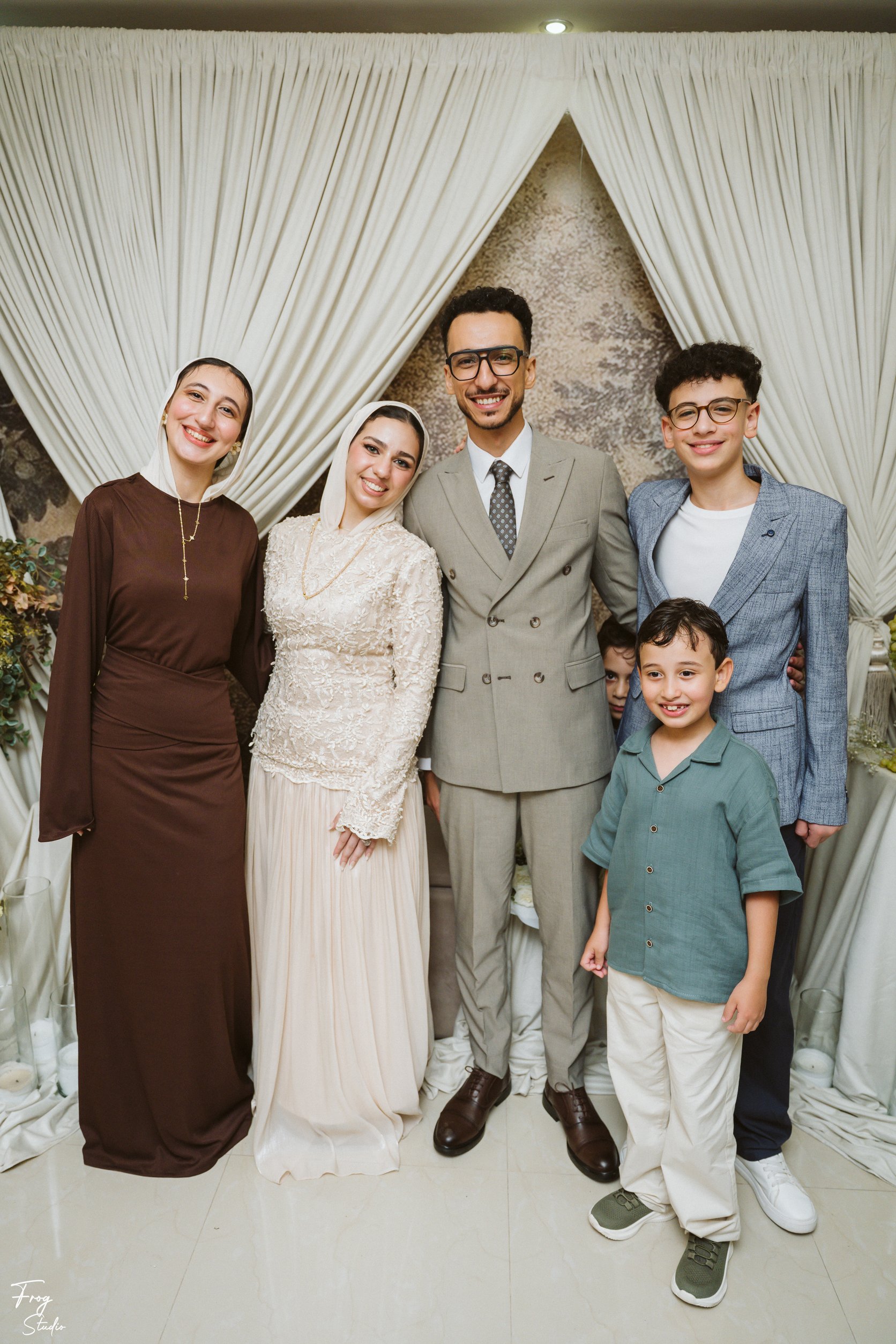 Two ladies in long dresses with Mohamed and Reem, a boy in a green shirt standing in front