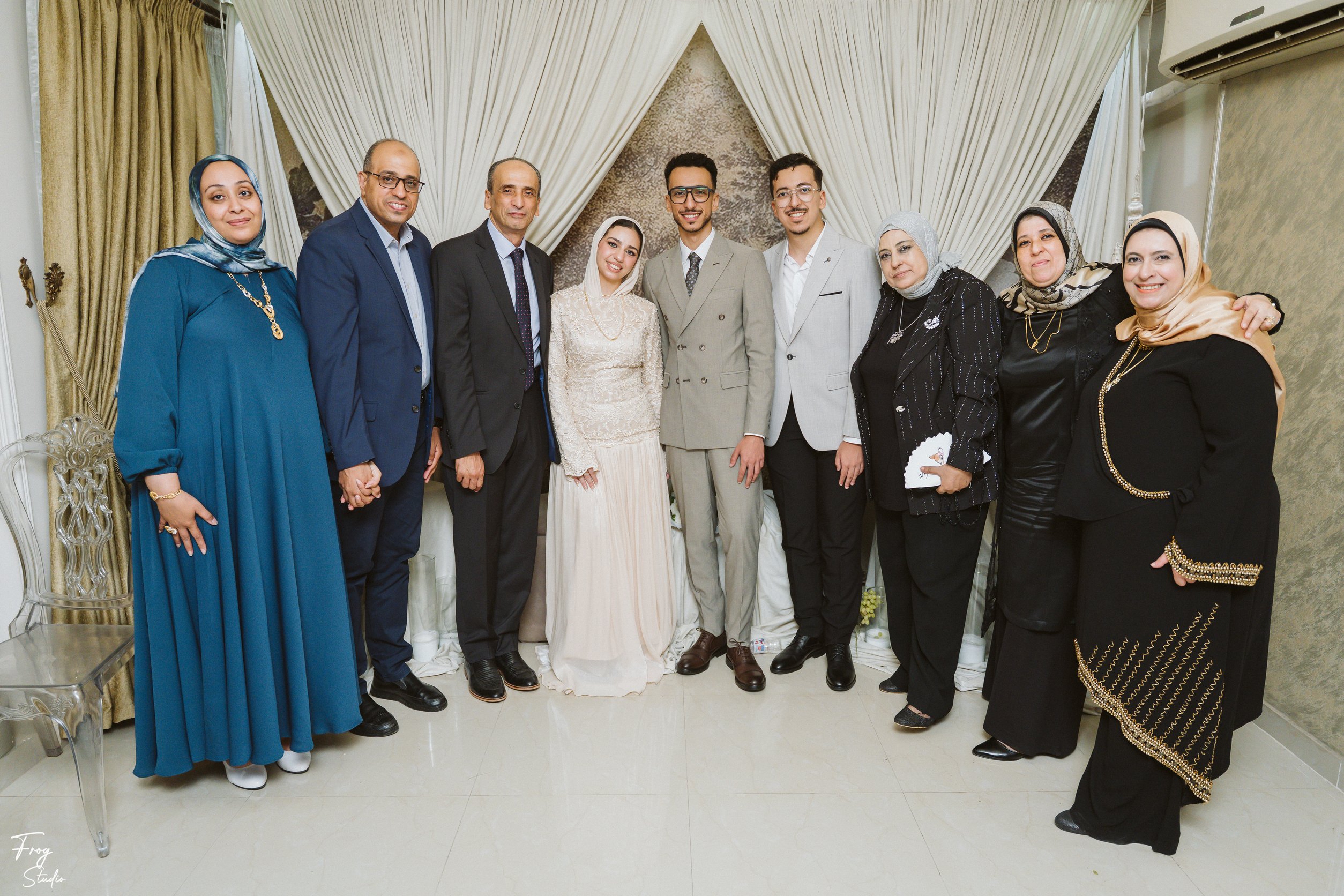 Nine family members in a row with Mohamed and Reem, several dressed in black and gold