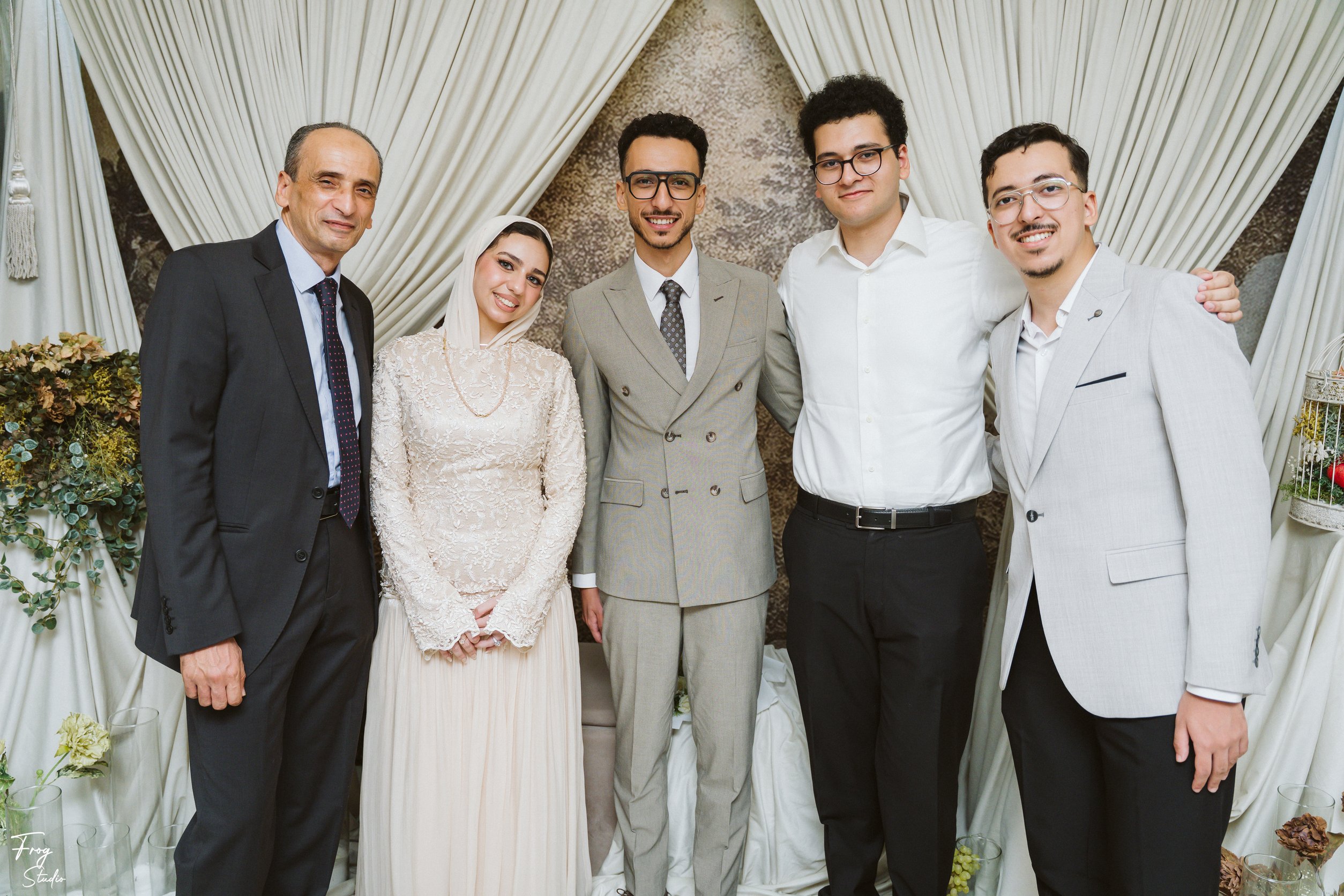 Mohamed and Reem with three men in dark suits and a young man in a white shirt