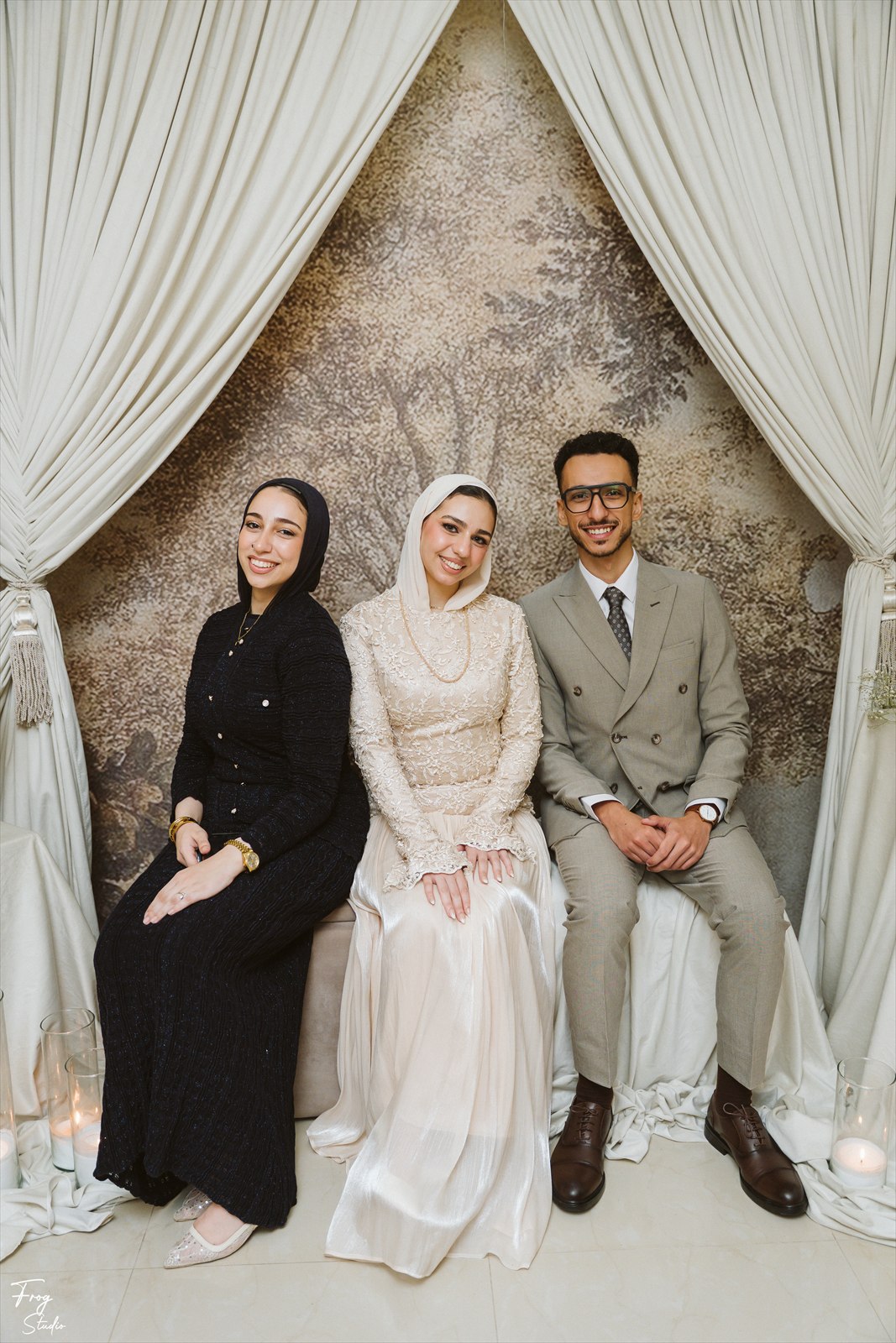 Reem and Mohamed seated together with a family member beside them
