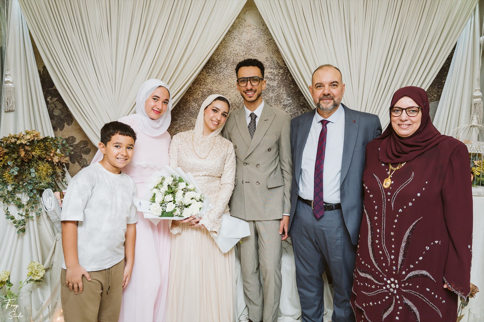 Reem holding her white rose bouquet with family members beside her