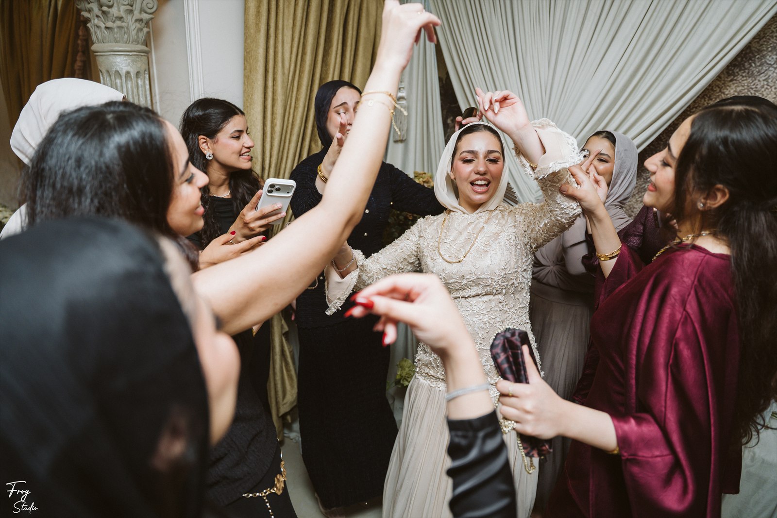 Reem at the centre of a circle of clapping family, celebrating on the dance floor