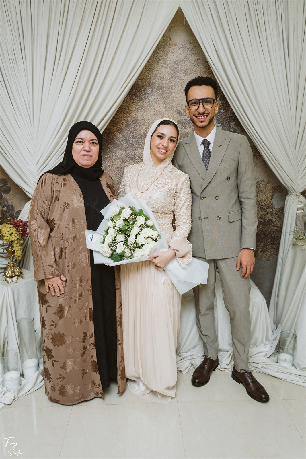 Reem holding her bouquet, photographed with Mohamed and a family member