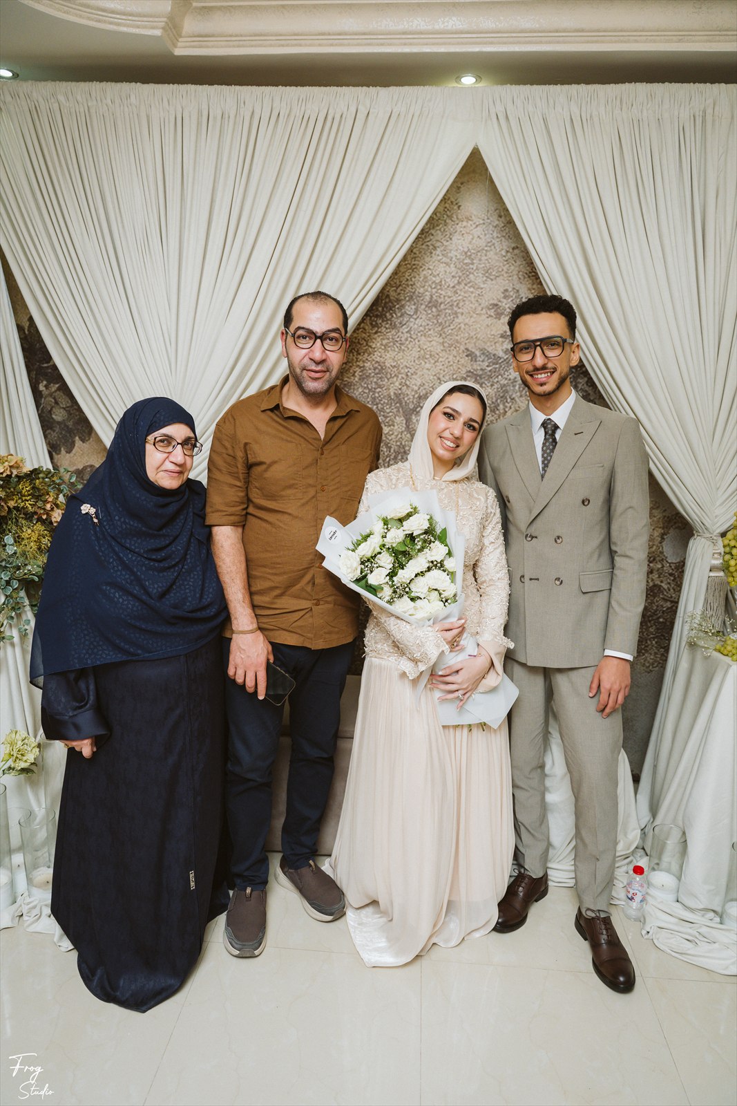 Reem and Mohamed standing with a family member, smiling